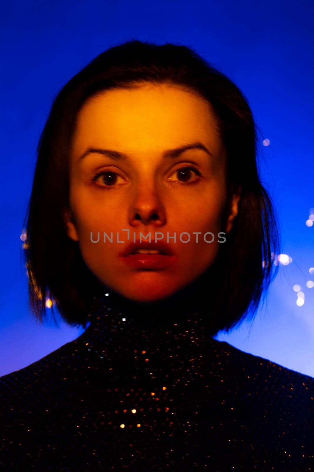 beautiful brunette woman with orange light on her face. High quality photo