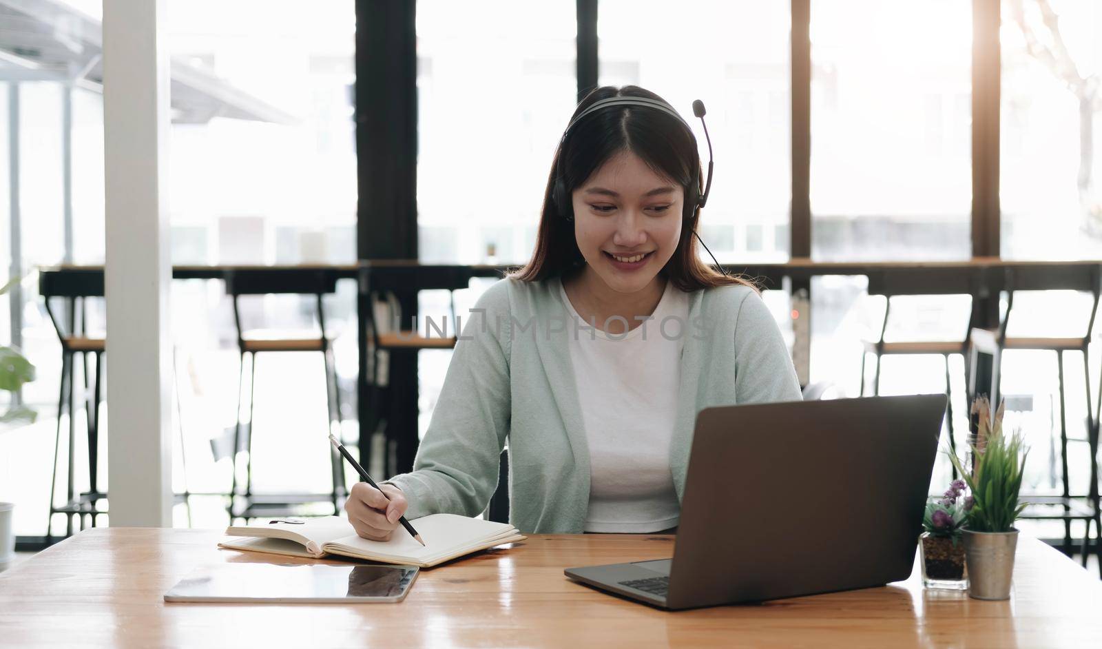 Asian woman wearing headphones study online watching webinar podcast on laptop listening learning education course conference calling, elearning concept..