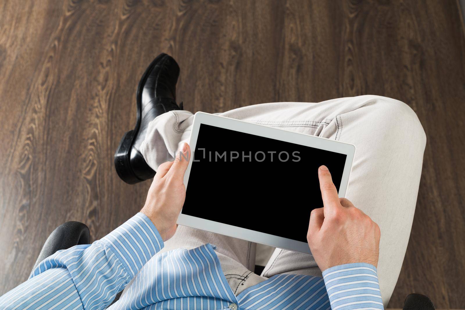 close-up of men's hands with a computer tablet. Businessman works in the office