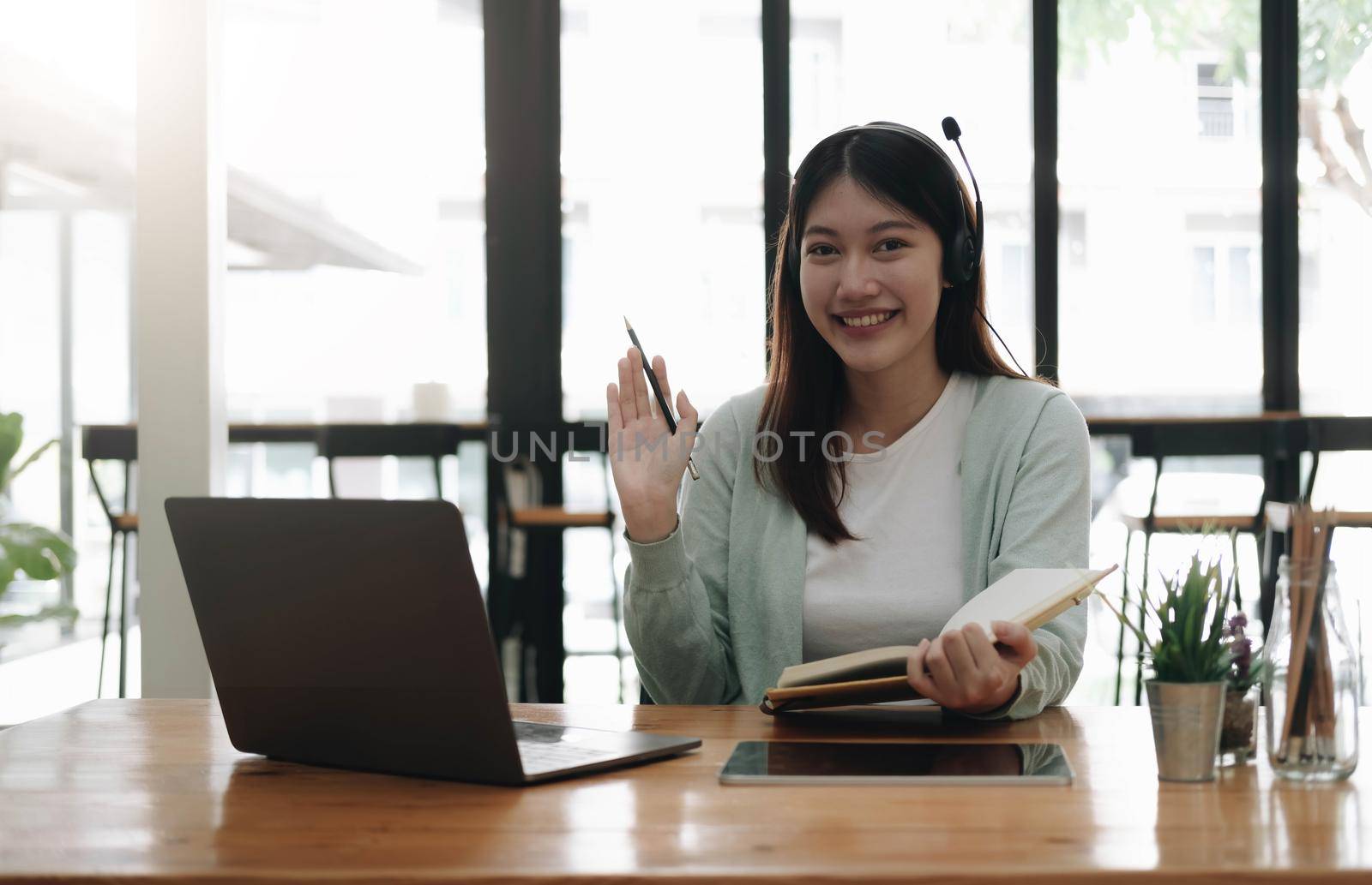 Asian woman wearing headphones study online watching webinar podcast on laptop listening learning education course conference calling, elearning concept. by wichayada
