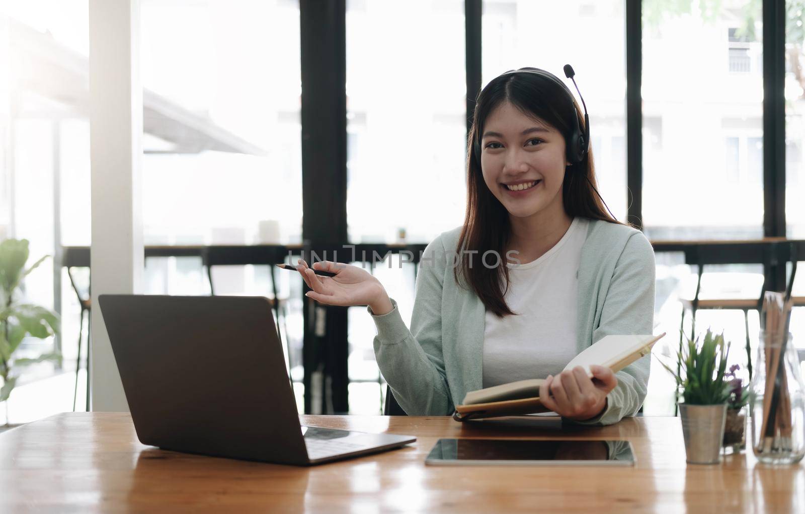 E-learning Online Education concept. Asian woman attentive student student video conference e-learning with teacher on laptop computer at home.