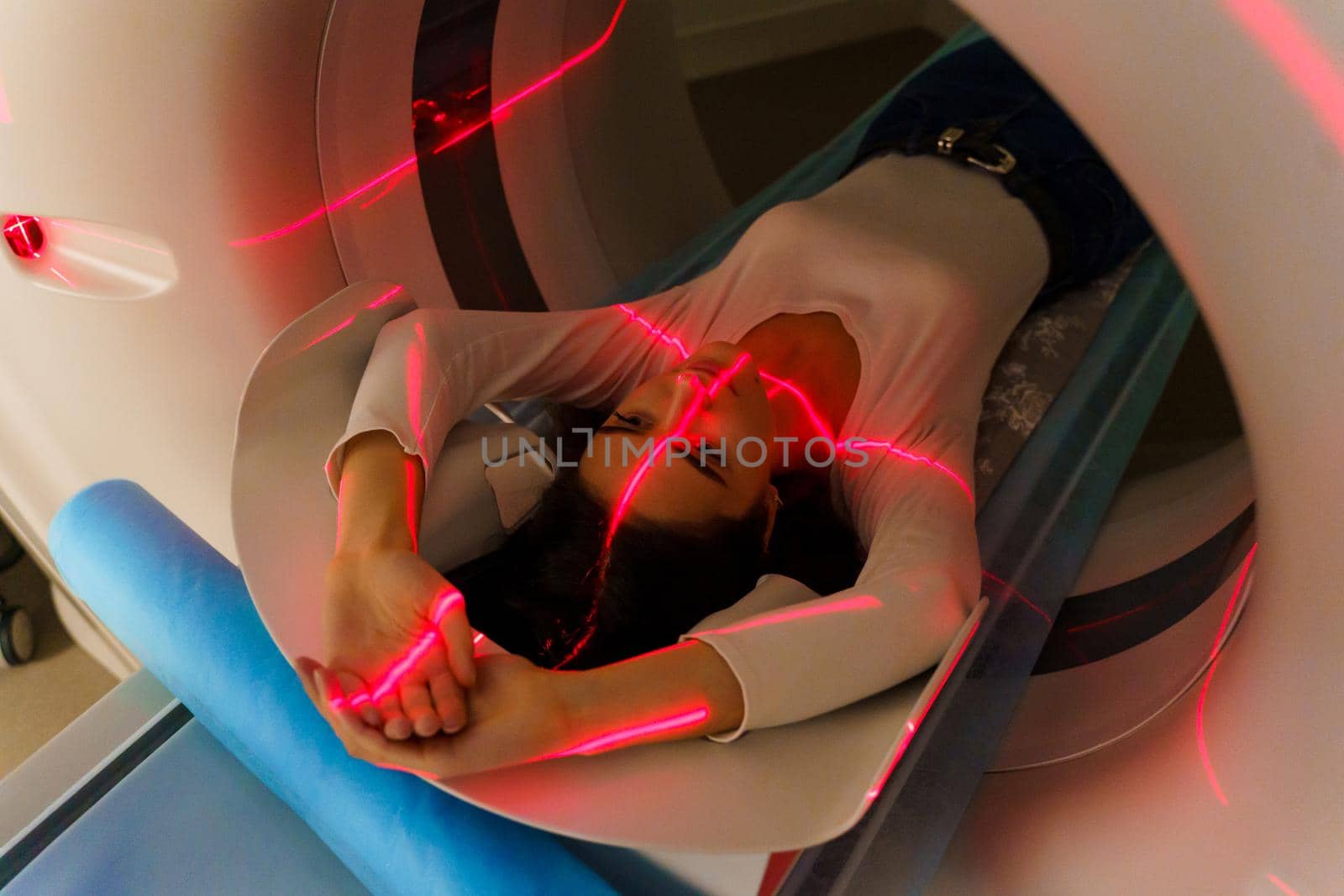 Red rays scan a girl on computed tomography CT scan of the abdomen for a woman to cure appendicitis, tumors, cysts, abdominal aortic aneurysm by Rabizo