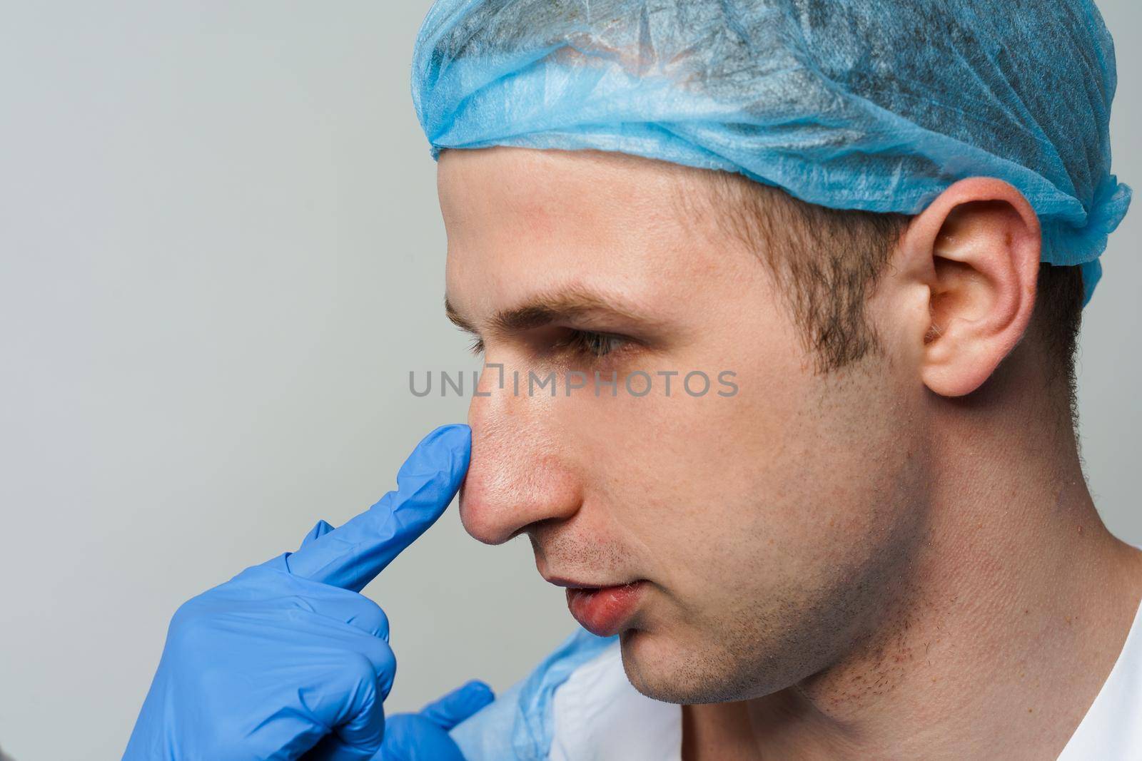 Facebuilding. Septoplasty and nose rhinoplasty. Doctor touches man nose on consultation. Inspection before plastic surgery. Cosmetic rejuvenating facial treatment.