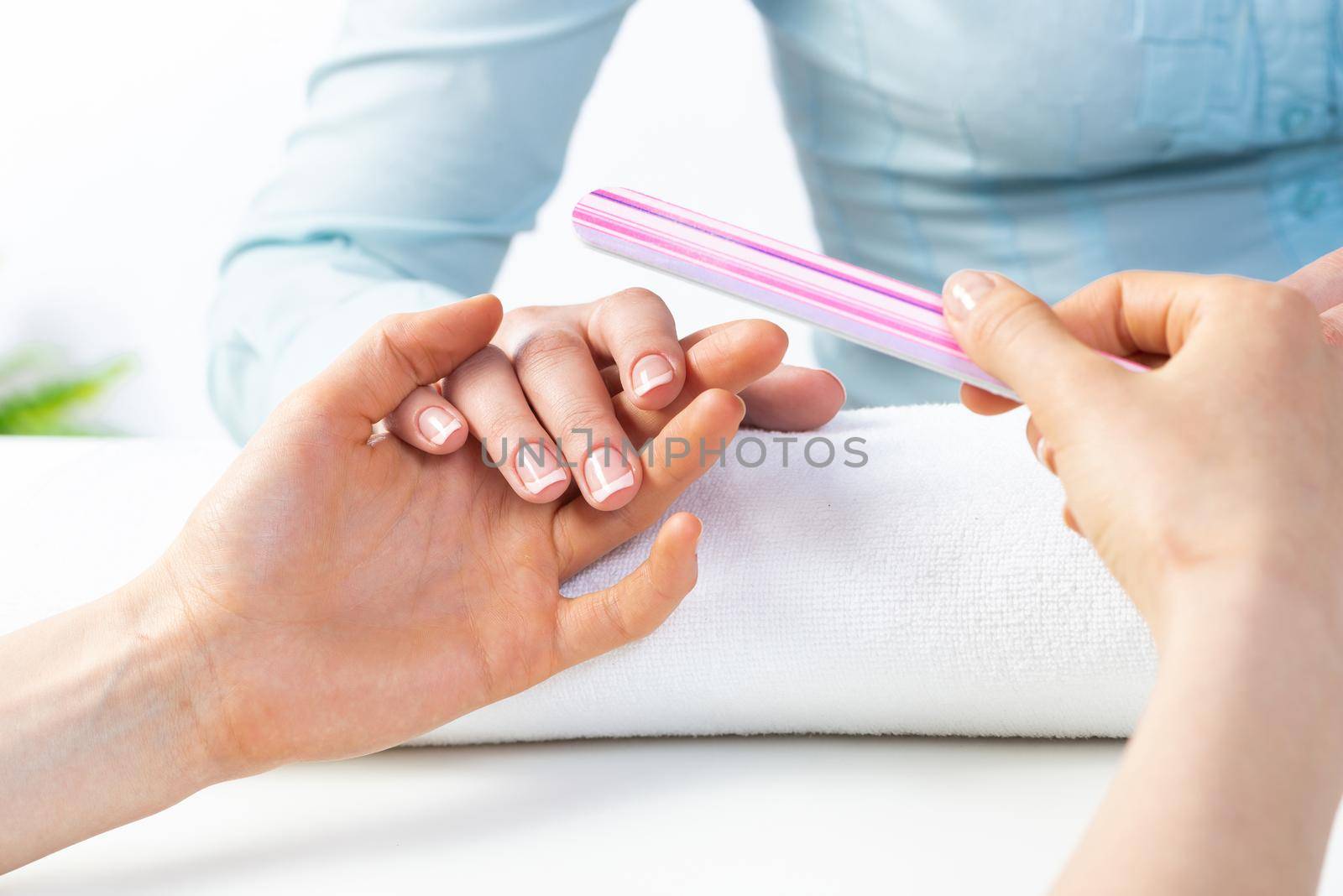 Manicurist using nail file and create clean shape by adam121