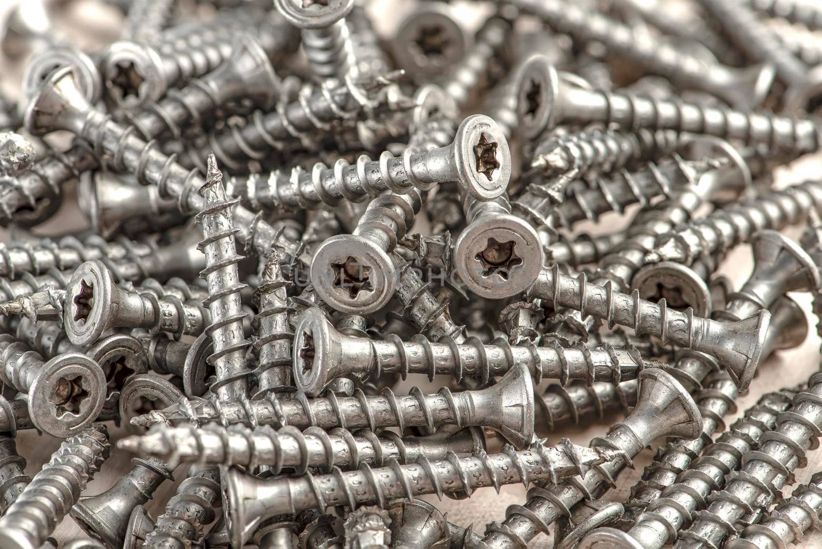 Close-up of universal silver screws with torx head. Self-tapping screws for wood, plywood or chipboard. Torx screws close up