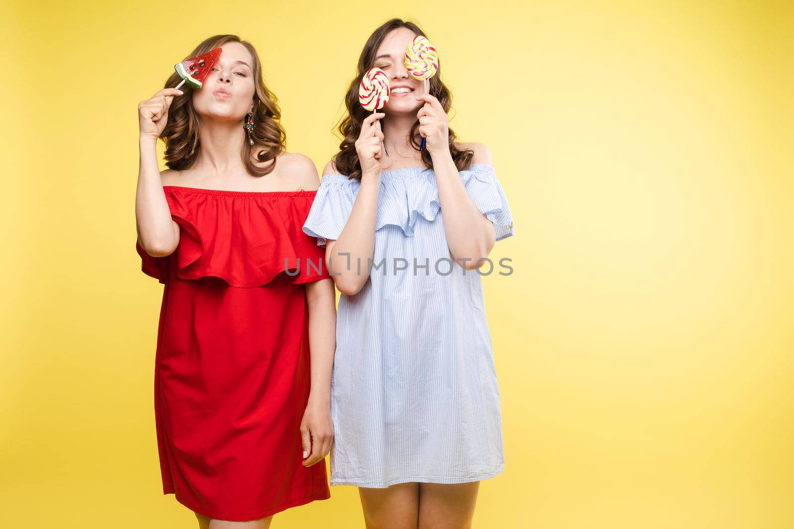 Horizontal portrait of two cheerful young women having fun together on background by StudioLucky