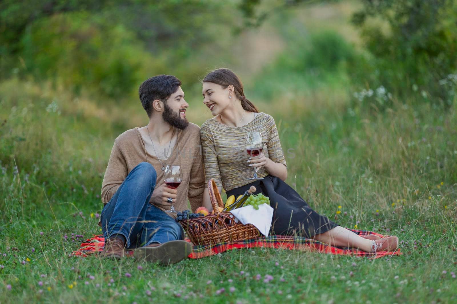couple drinking wine from glasses in nature