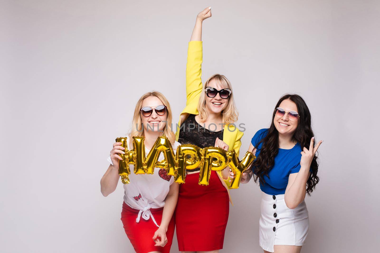 Cheerful women celebrating birthday party and posing by StudioLucky