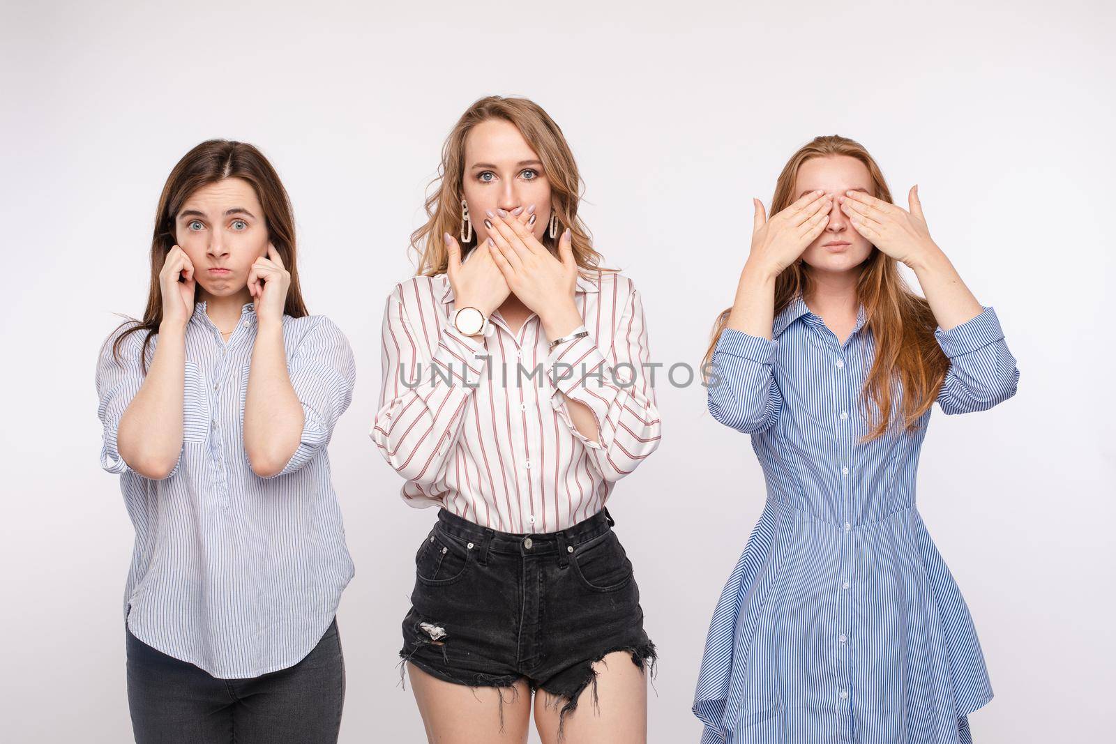 Three young woman friend posing with closing eyes ears and mouth looking at camera medium shot by StudioLucky