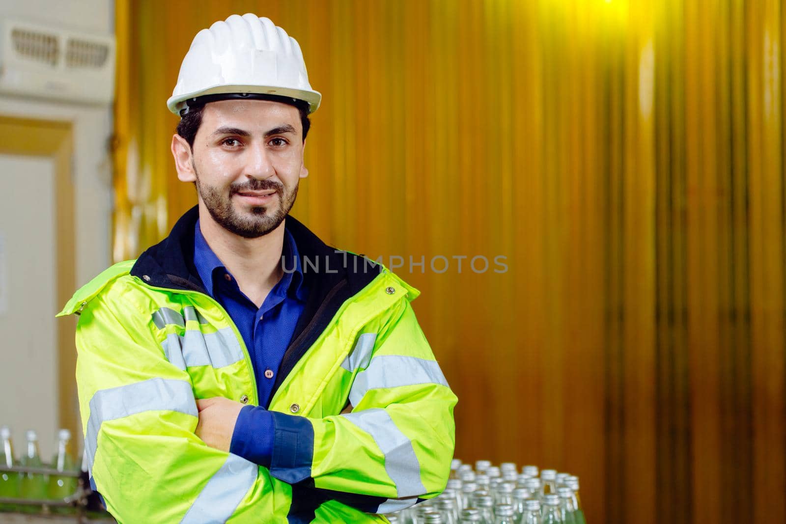 Portrait smart Latin worker in cargo port logistic warehouse standing confident with safety suit.
