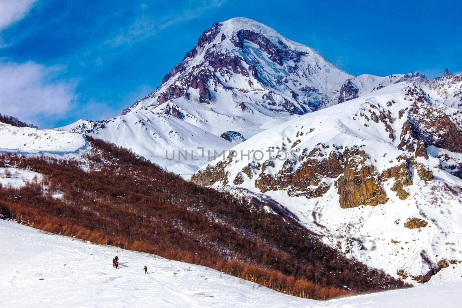 Amazing colorful mountain landscape with a group of climbers in the distance. Georgia, Caucasus, foothills of Kazbek.