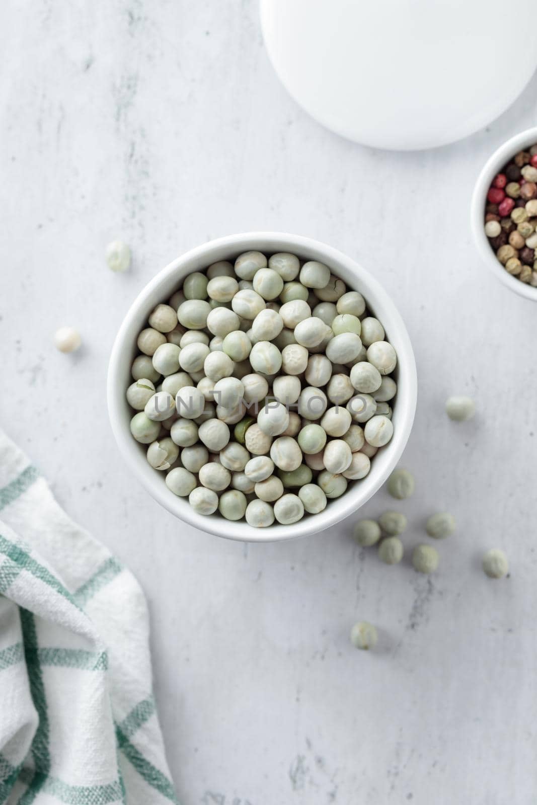 Raw Dried Green Peas in a white bowl on a table