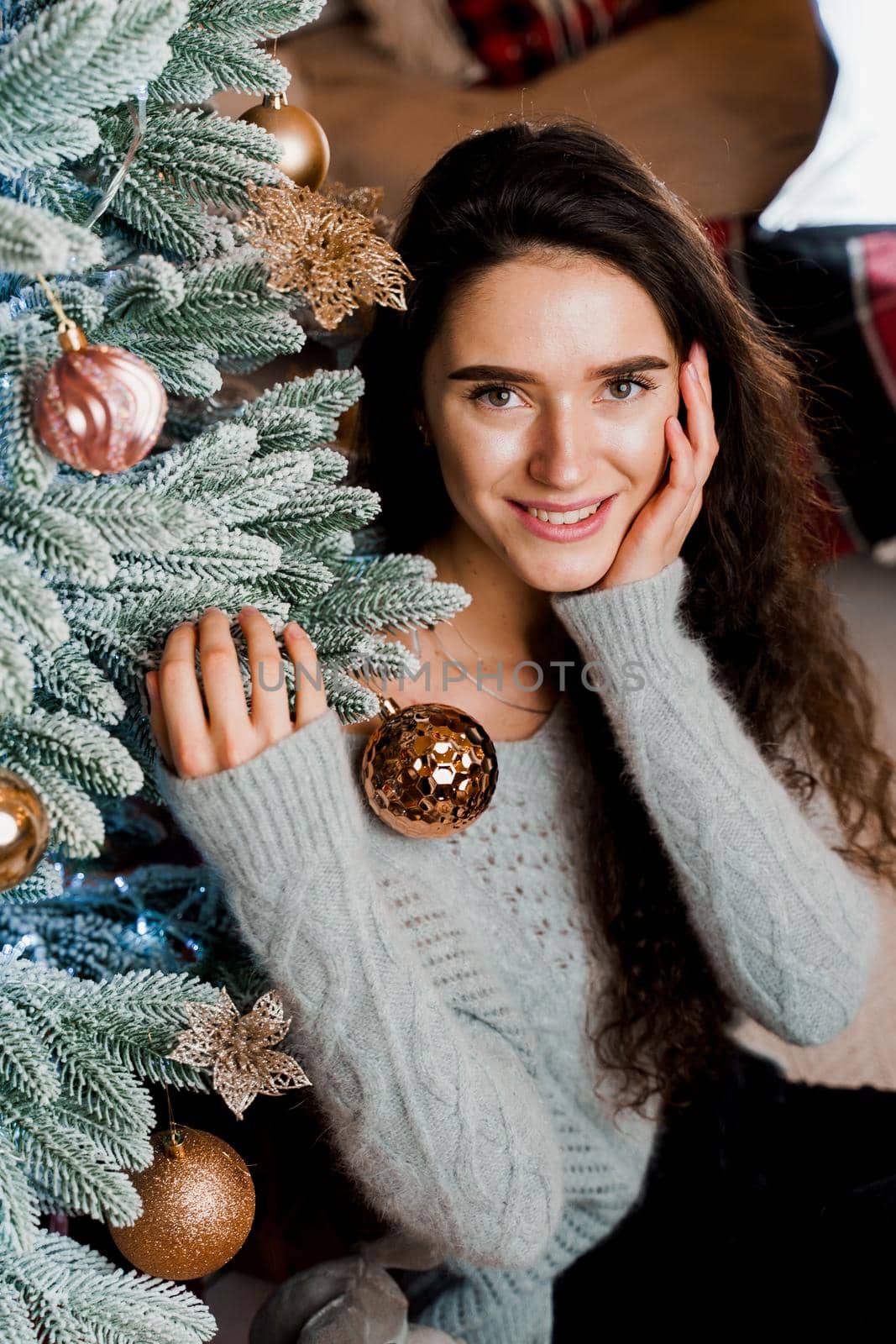 Portrait of a girl near the Christmas tree close-up. New Year celebration. Waiting for gifts.