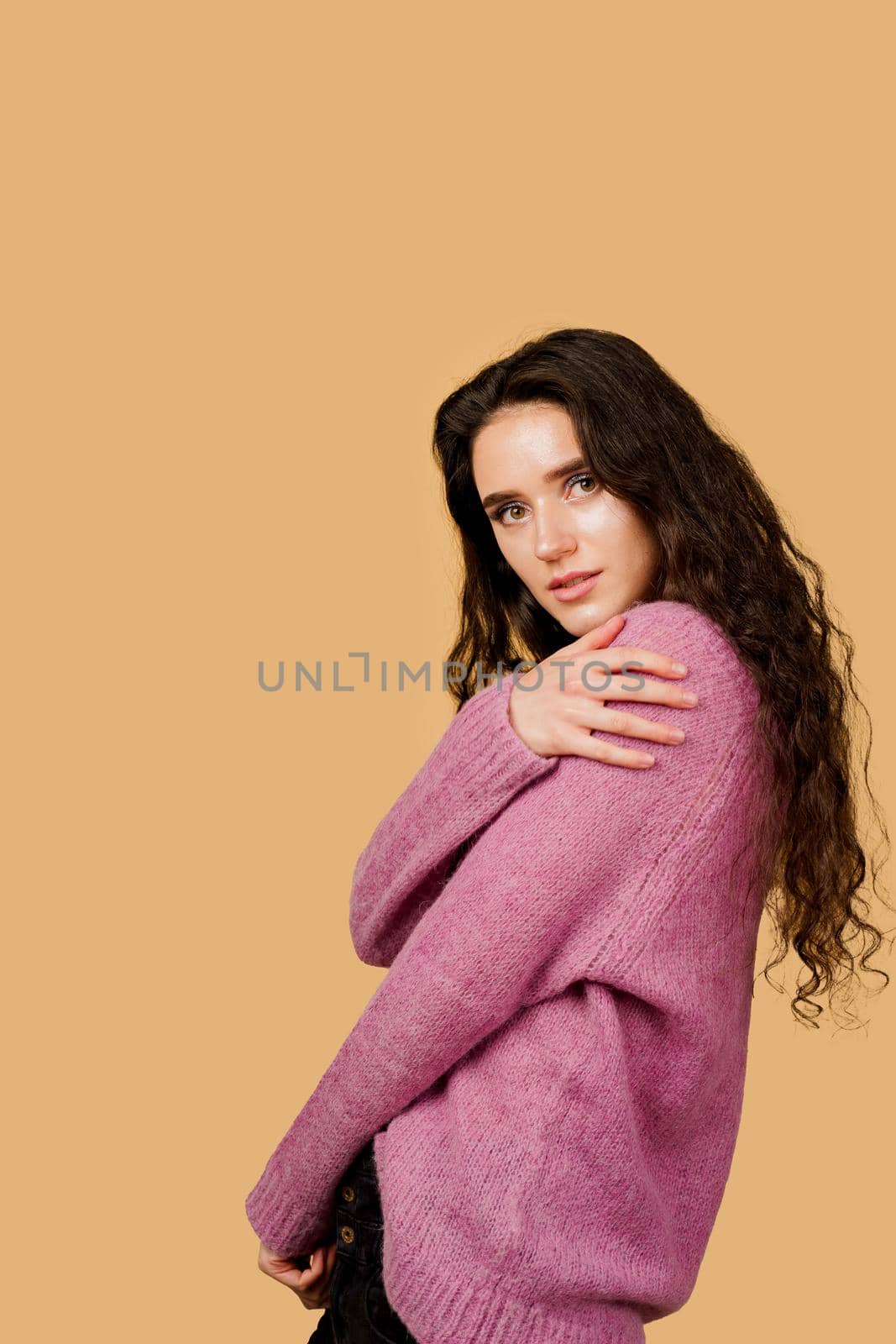 Fashion model posing in studio isoleted on yellow background. Lifestyle of pretty girl. Happy lady weared pink pullover.