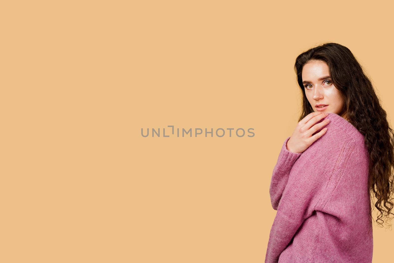 Fashion model posing in studio isoleted on yellow background. Lifestyle of pretty girl. Happy lady weared pink pullover.