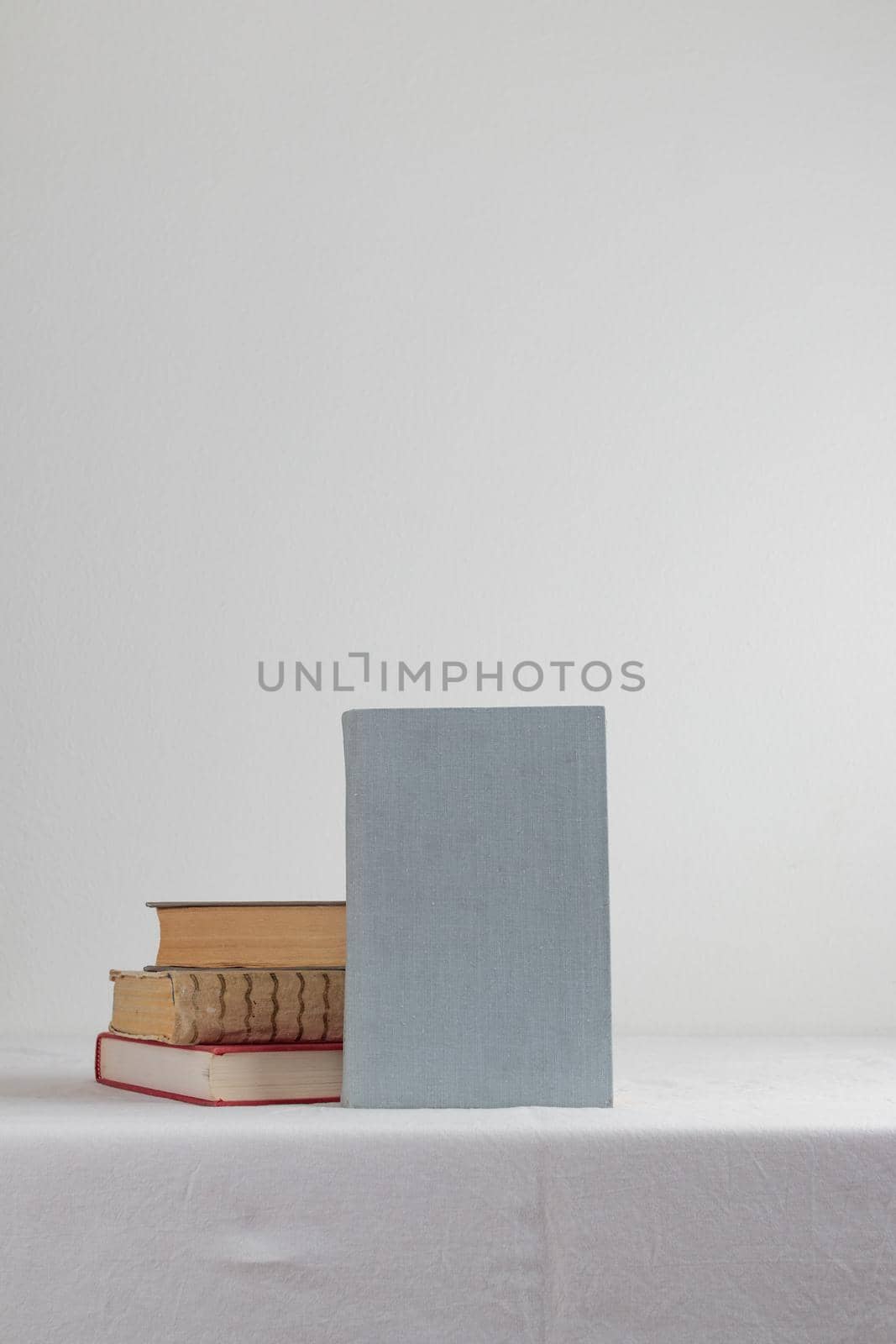 Stack of old rustic vintage books on white table