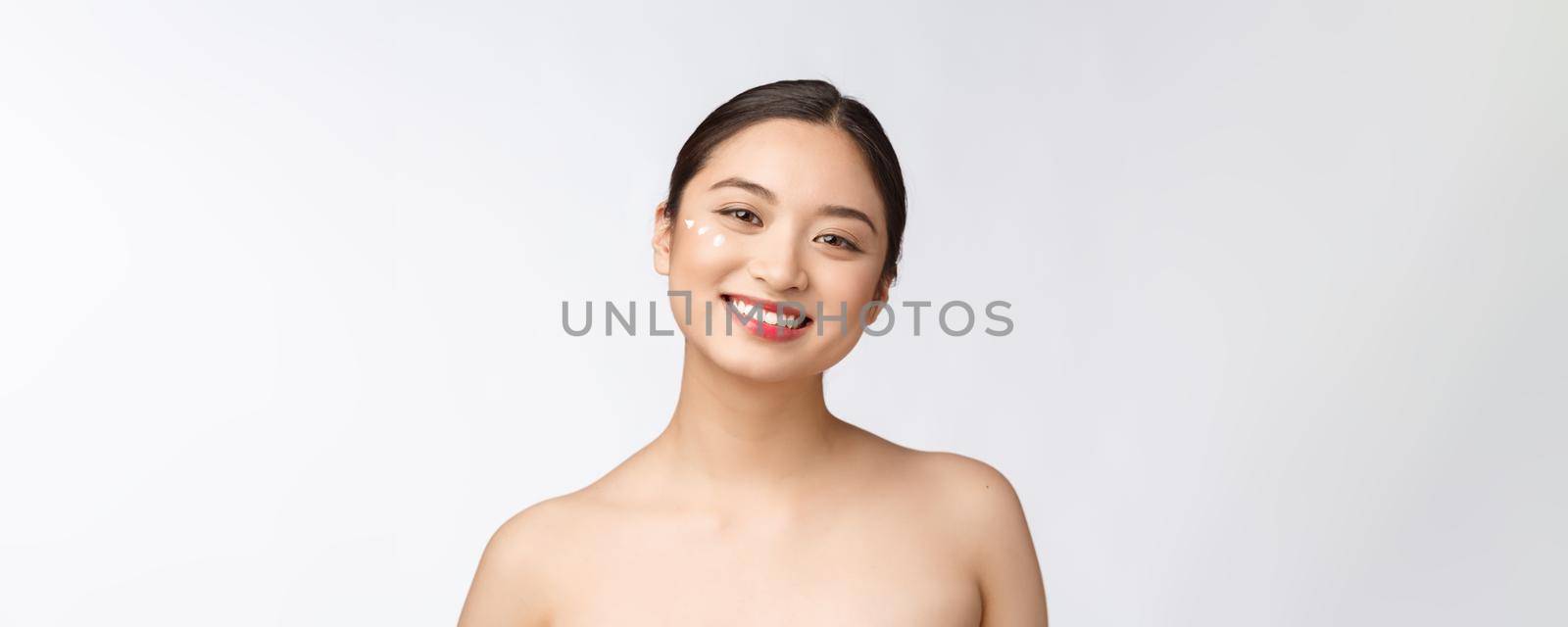 Skin care beauty woman. Beauty woman smiling applying cream. Beauty portrait of beautiful Asian Caucasian female model isolated on white. by Benzoix