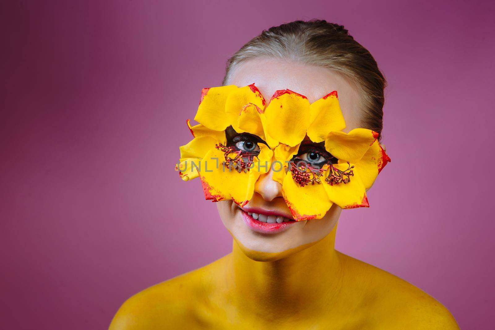 Girl model with yellow flowers around her eyes. The girl's body is painted yellow by deandy