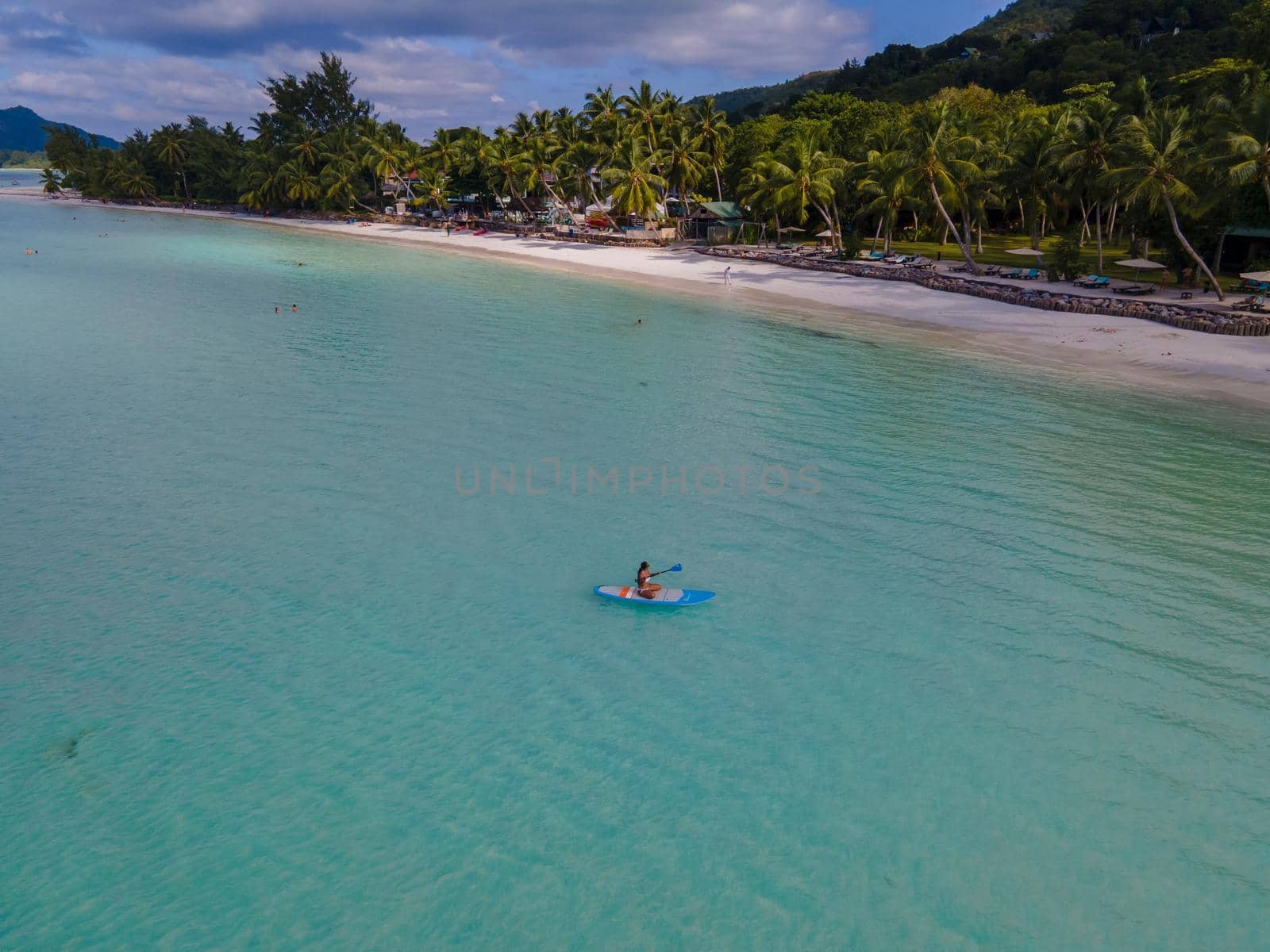 woman with paddle board sup in ocean, Praslin Seychelles tropical island with withe beaches and palm trees, beach of Anse Volbert Seychelles by fokkebok