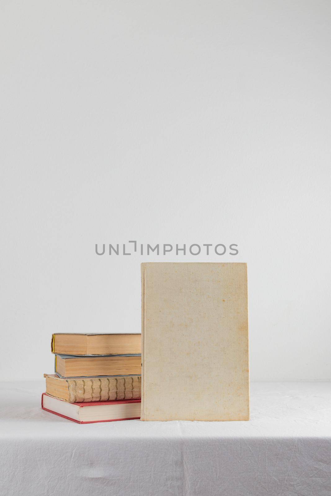 Stack of old rustic vintage books on white table