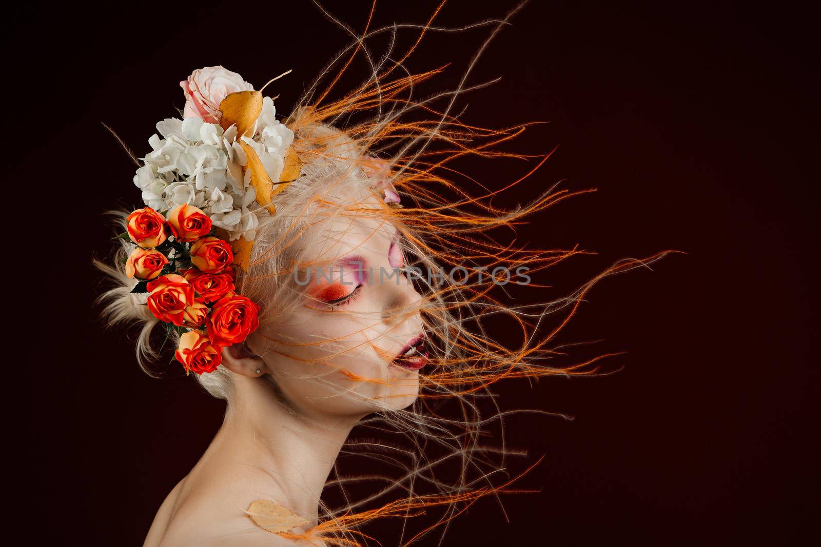 A girl with lively curly hair and flowers in her head. Art object. Flower girl fairy