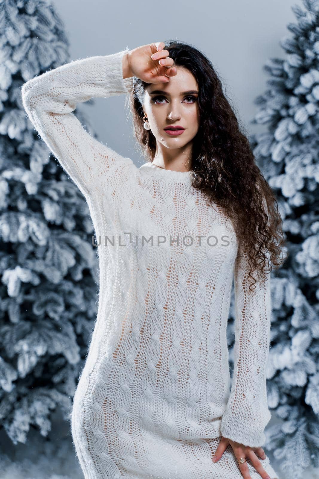 New year celebration.Happy girl with falling snow. Young woman weared in a warm white pullover and white socks. Winter holidays in snowy day. by Rabizo