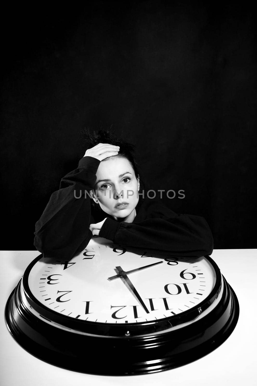 sad woman with big clock, black background by shilovskaya