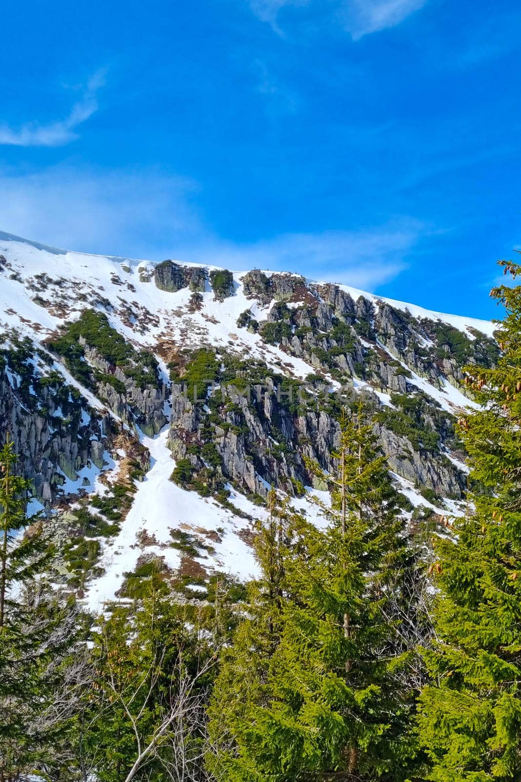 The tops of the mountains with snow against the blue sky