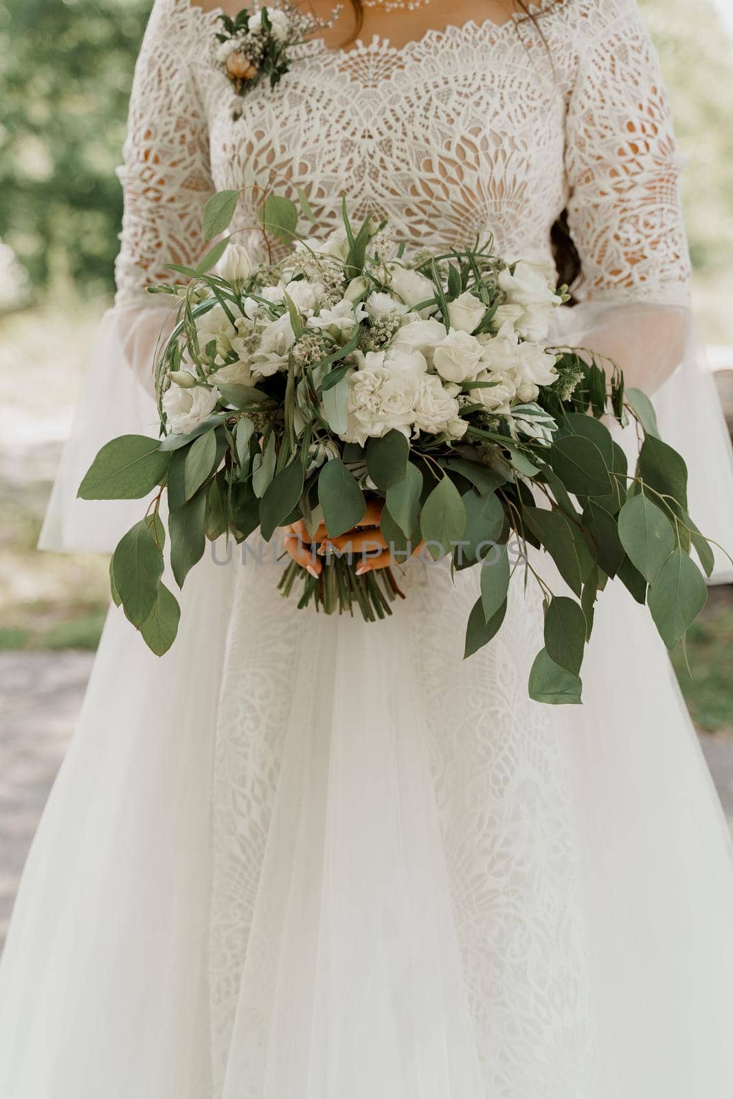 Wedding bouquet with white roses and green leaves. Bride in dress holds bouquet. Advert for wedding agency