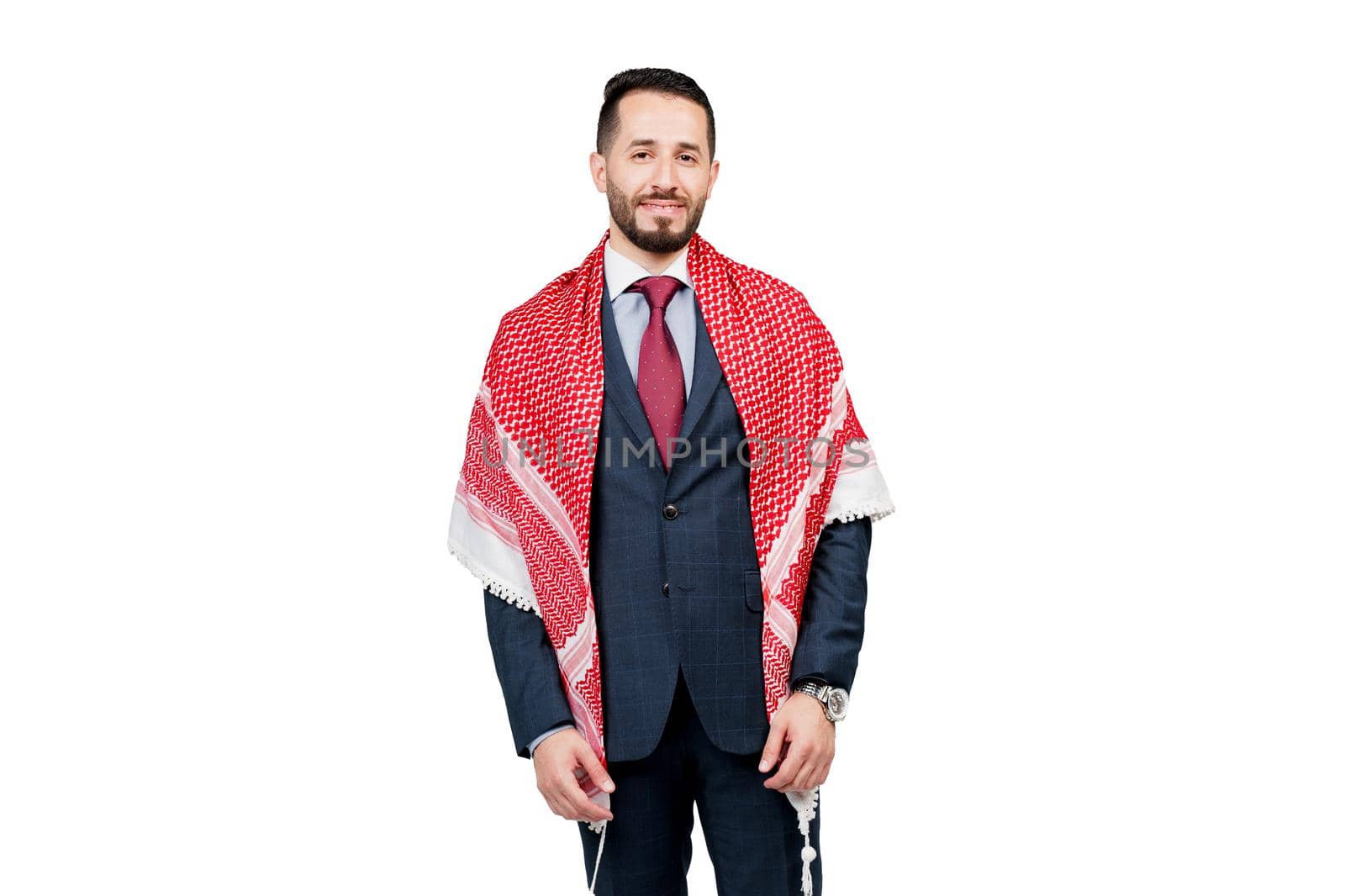 Handsome arabic businessman in suit and shemagh smiles on white blank background in studio. Business portrait of successful man