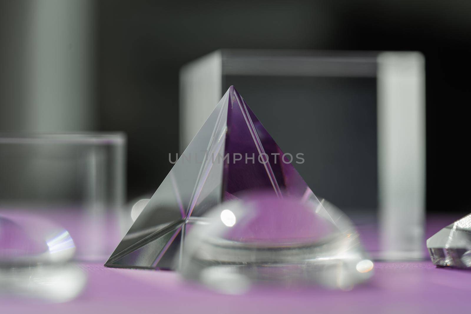 Crystal prism refracting light, magic crystals and pyramid, sphere and cube on purple background. Spiritual healing crystal practice. Feng Shui, good energy flow concept, esoteric background..