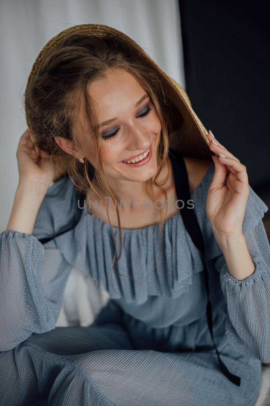 Beautiful young woman with long blonde hair in blue vintage dress holding blue flowers. Romantic postrait of smiling girl