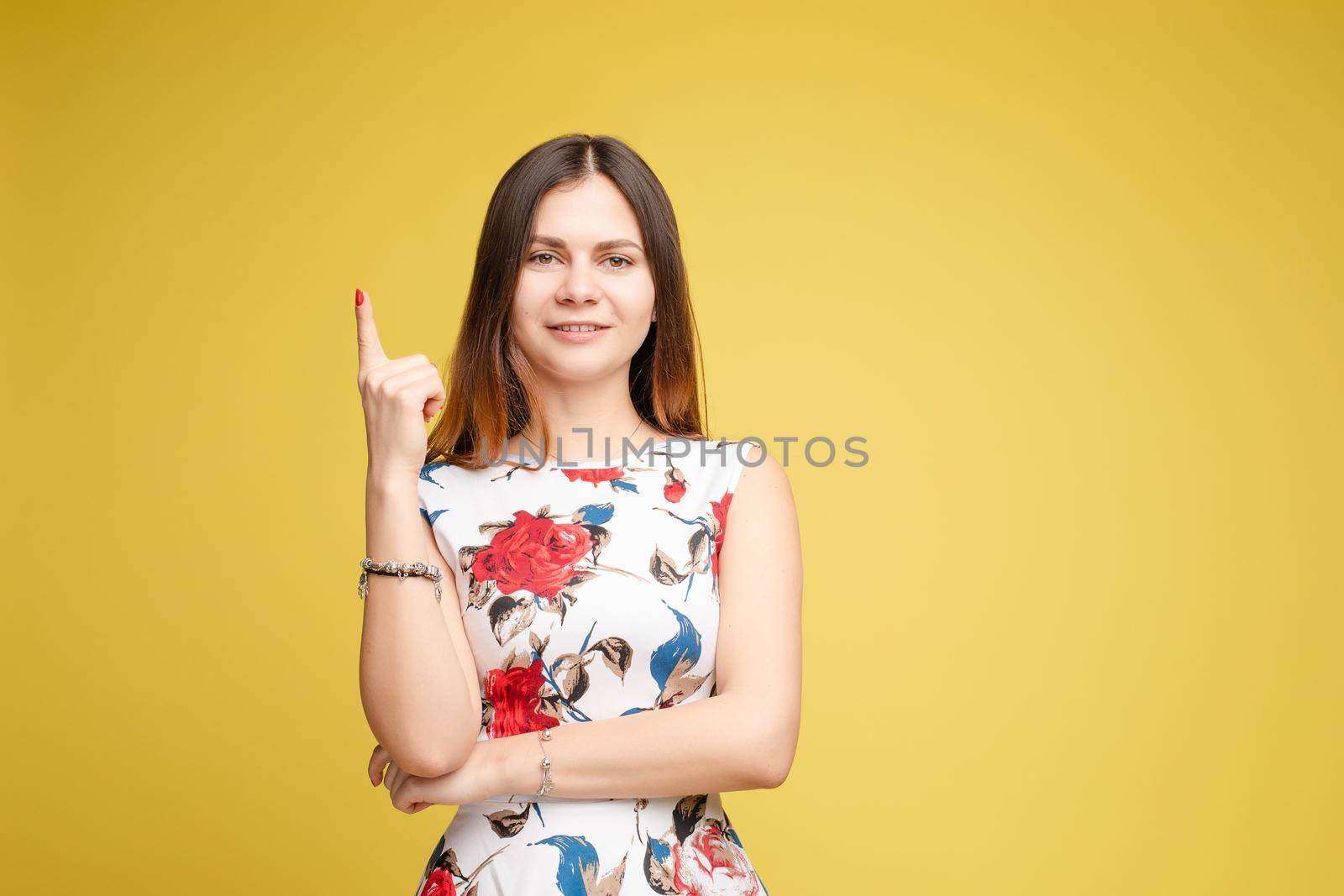Side view studio portrait of stylish attractive young woman looking away and holding finger. Sudactive feminine model in black with make up plump lips and big eyes holding hand. Concept of style.