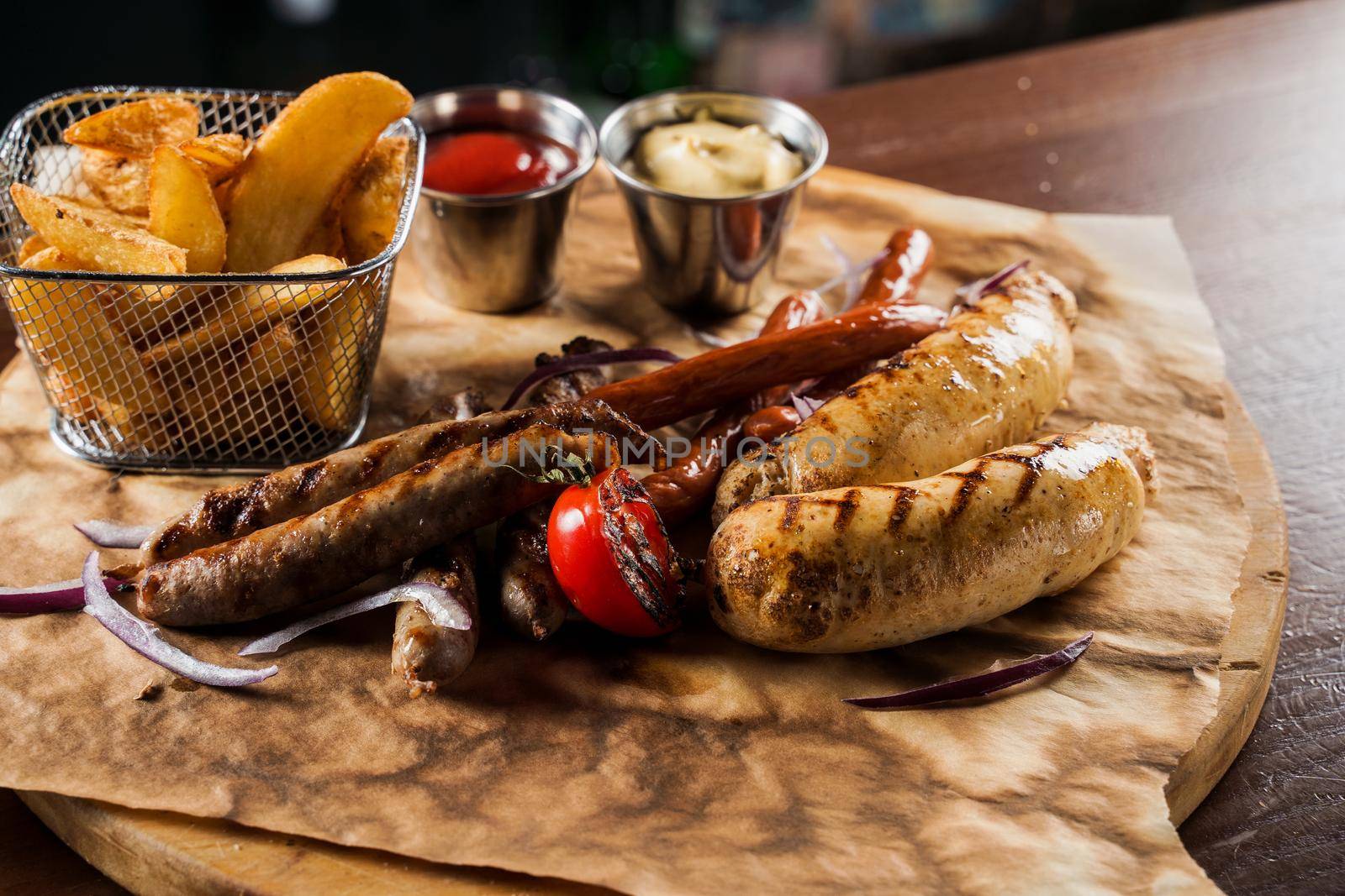Barbecue grilled hot dog with yellow mustard and ketchup on wooden background. Hot dog sandwich with potato fries and sauces.