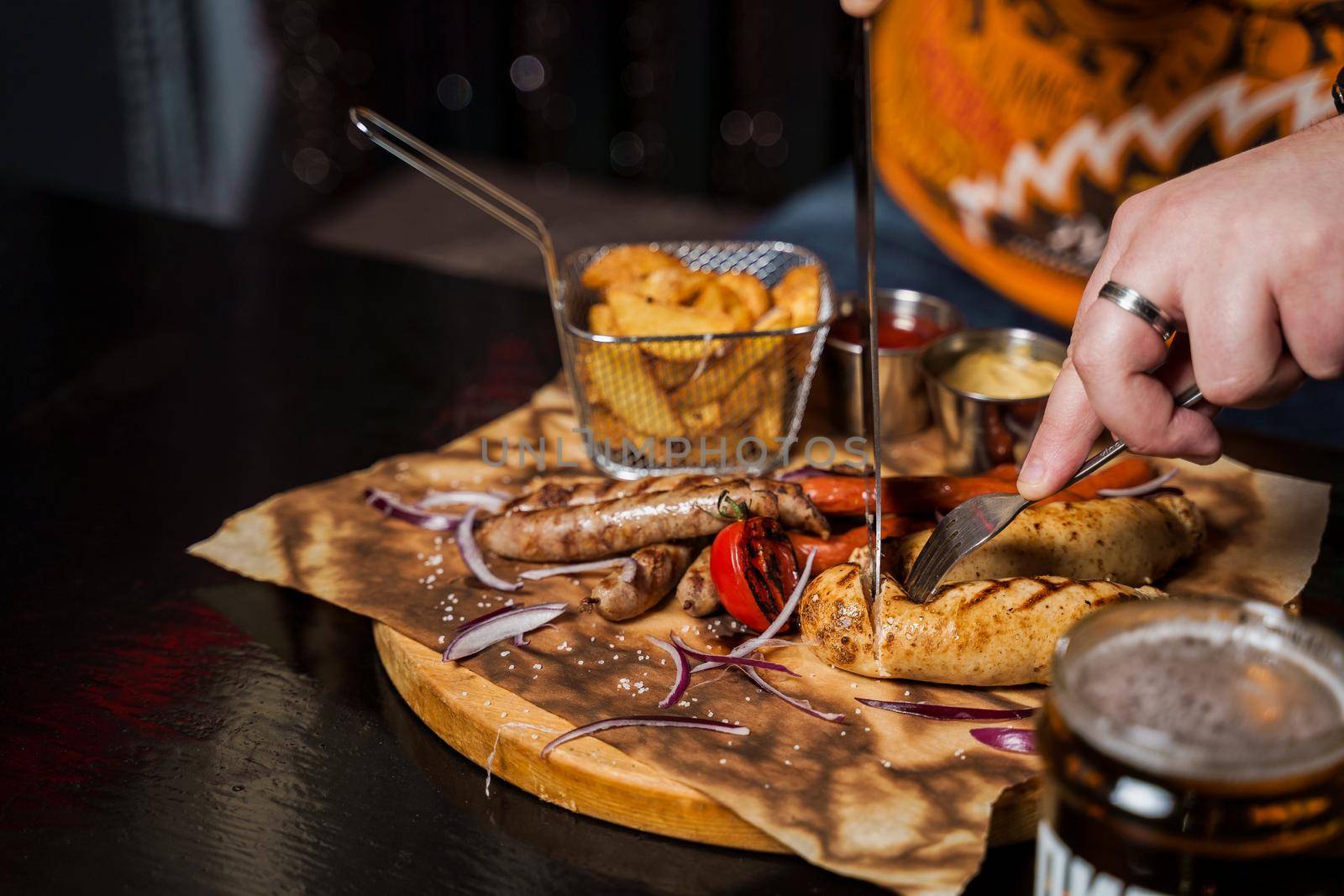 Barbecue grilled hot dog with yellow mustard and ketchup on wooden background. Hot dog sandwich with potato fries and sauces.