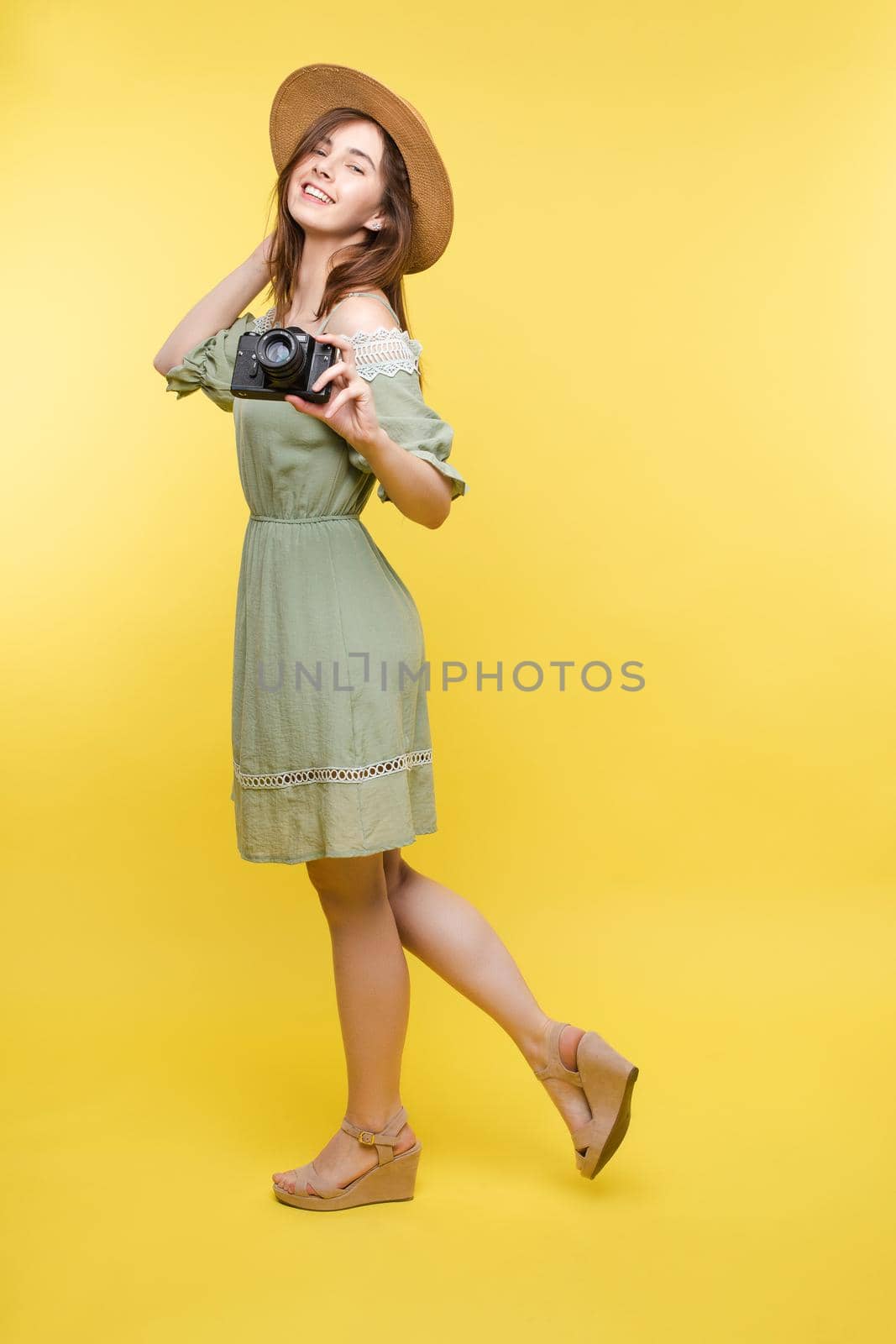 Young girl in straw hat and glasses keeping camera by StudioLucky