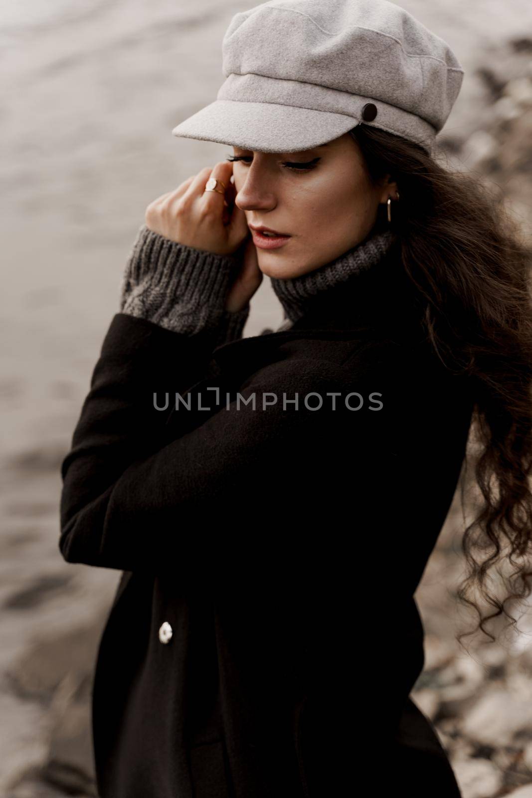 Attractive girl tourist travels around her country. Young woman with curly hair looks at the lake and dreams about her life