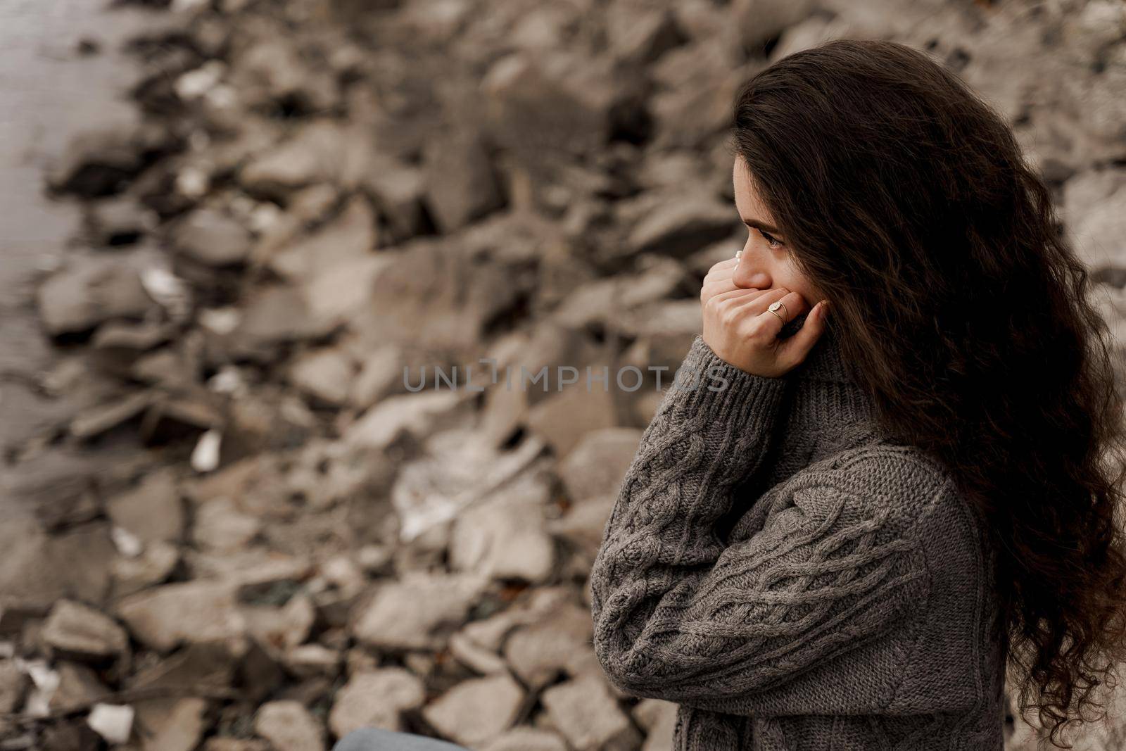 Girl with curly hair on the background of birch with stones and lake in autumn by Rabizo