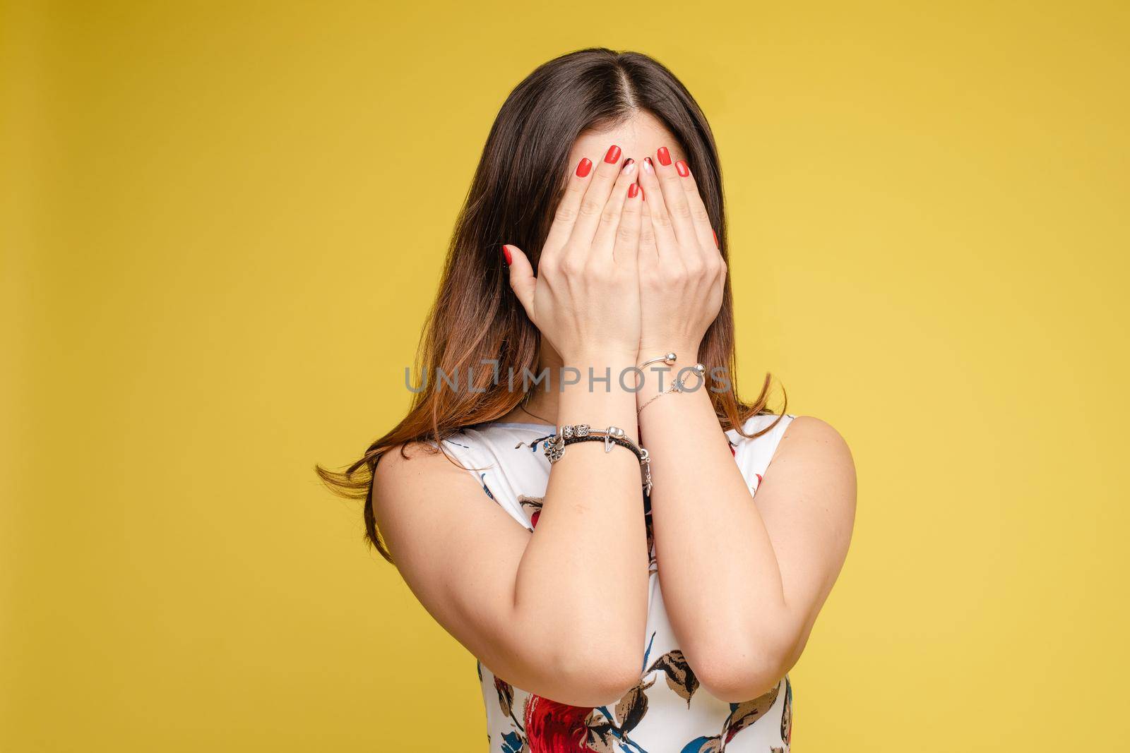 Amazed lovely woman covering face with hand by StudioLucky