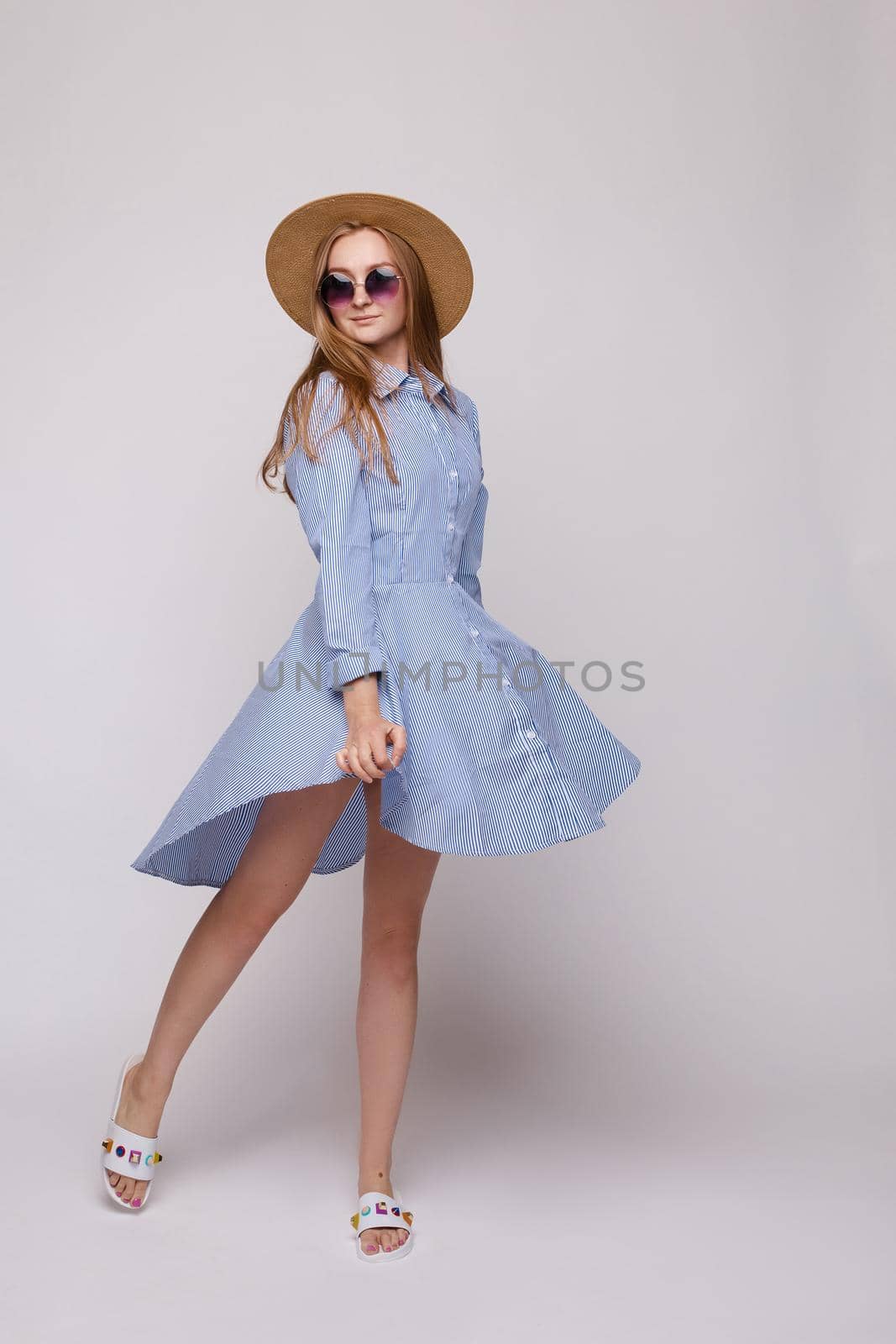 Young girl in straw hat and glasses on isolated background in studio by StudioLucky