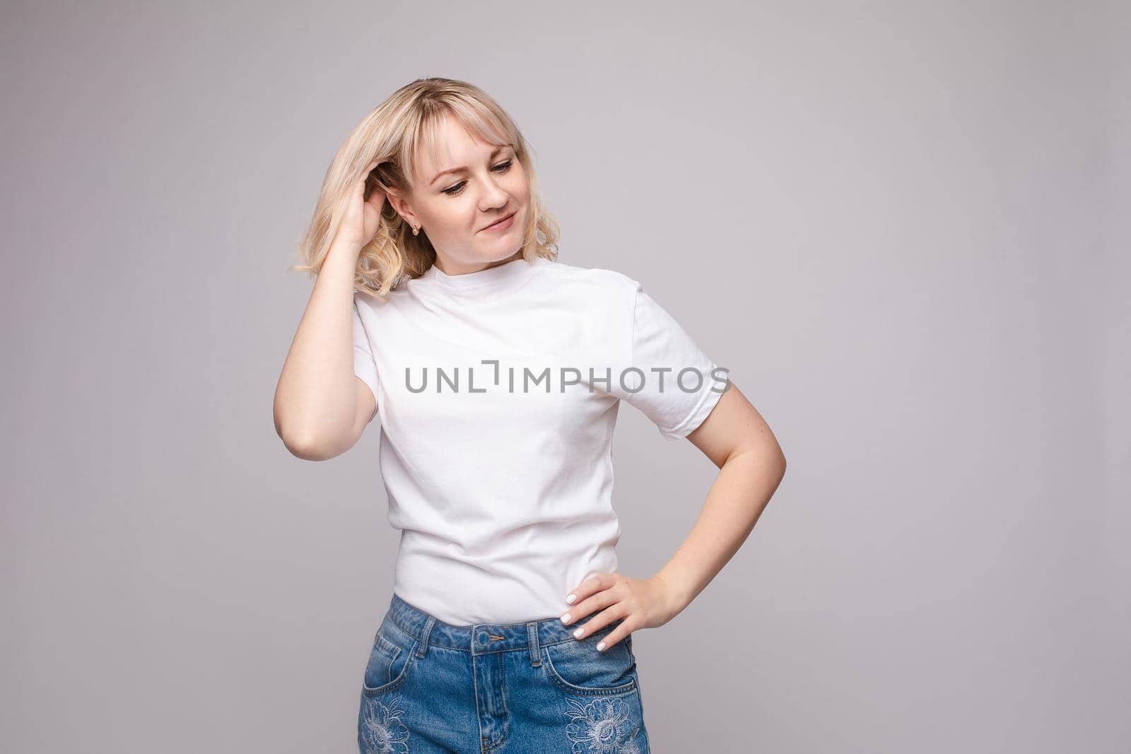 Portrait of happy fashion female with nice hairstyle and beautiful blue eyes posing at studio. Cheerful girl looking away and smiling. Isolated