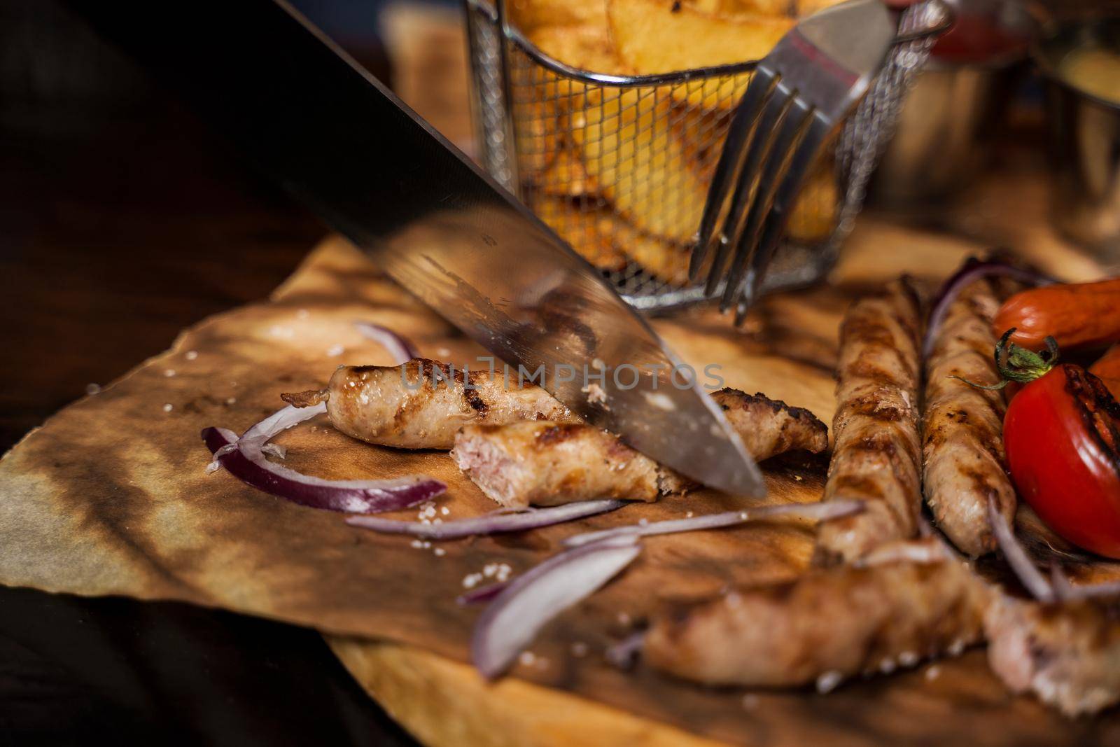 Barbecue grilled hot dog with yellow mustard and ketchup on wooden background. Hot dog sandwich with potato fries and sauces.