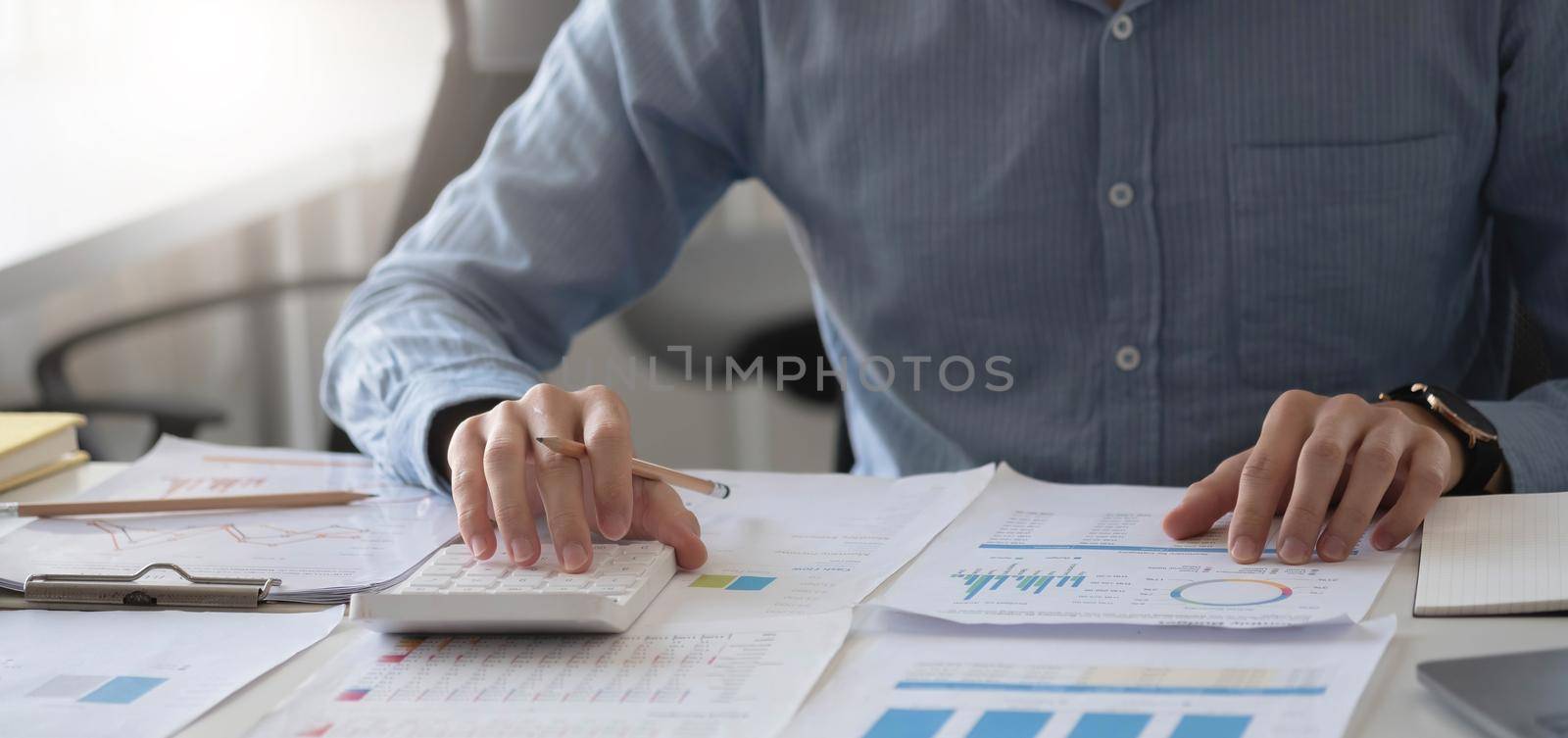 Close up businessman hand using calculator and working with laptop calculate about finance accounting at coffeeshop outdor.finance accounting concept by wichayada