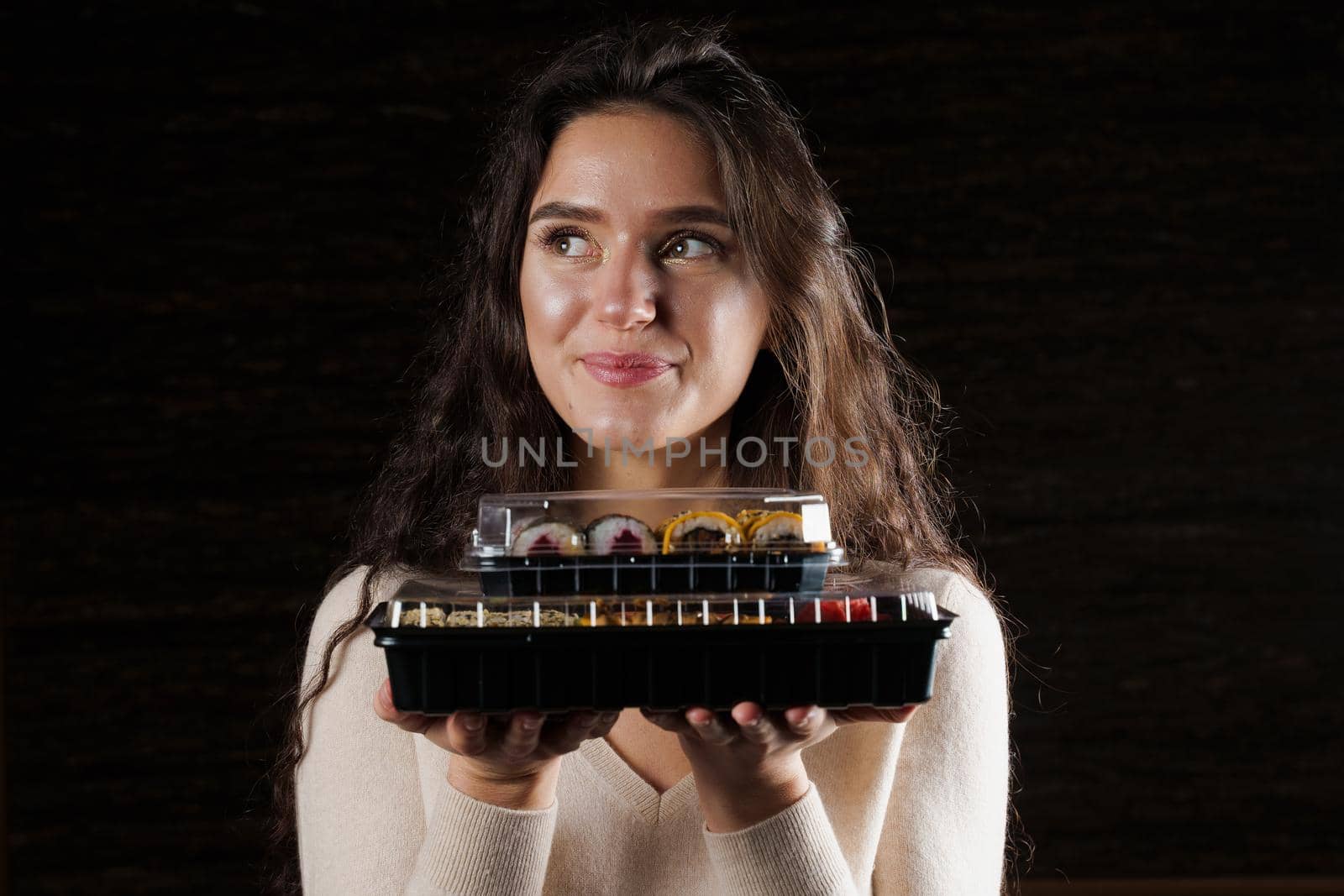 Girl with sushi. Food courier holding 2 sushi boxes . Delivery at quarantine coronavirus covid-19.