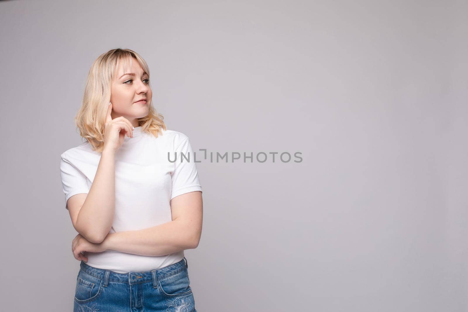 Portrait of happy fashion female with nice hairstyle and beautiful blue eyes posing at studio. Cheerful girl looking away and smiling. Isolated