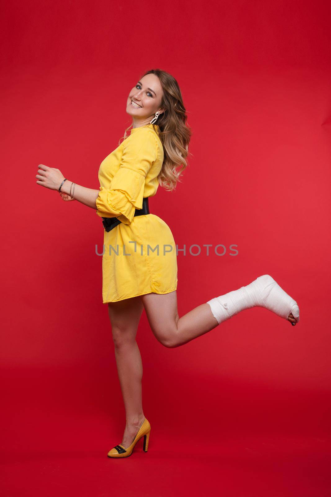 Cheerful girl in dress jumping with plaster. by StudioLucky