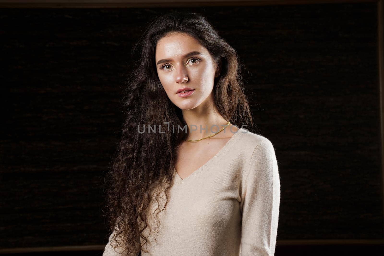 Fashion model posing in studio isoleted on black background. Lifestyle of pretty girl. Happy lady weared brown pullover.