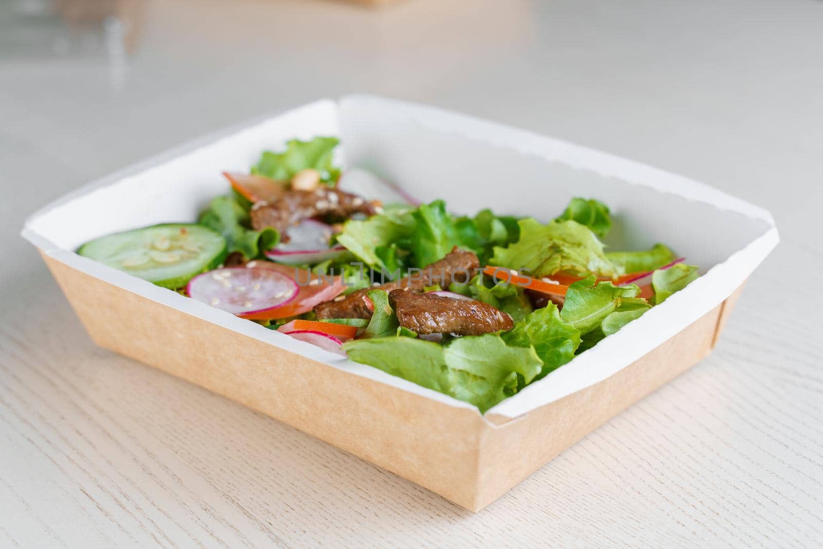 Green natural salads in eco thermo box with microgreen, veal, cucumber, tomato, cheese. Safety delivery at quarantine covid 19.