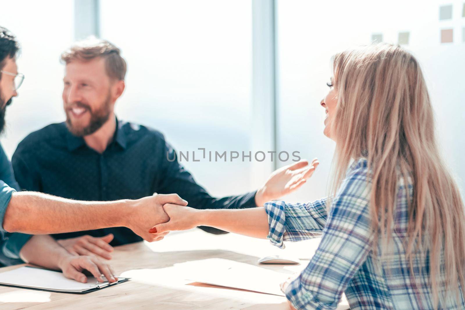 employer shaking hands with a young woman during the interview. concept of cooperation