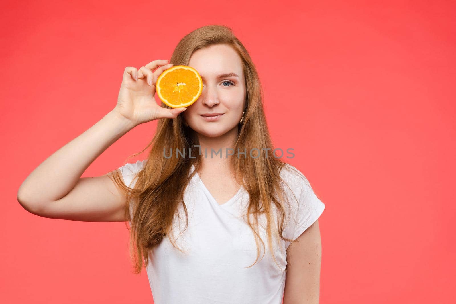 Cheerful young blonde posing with fresh oranges by StudioLucky